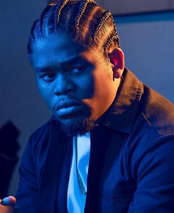Leon Simmons in a blue-lit portrait, turned slightly away, watching something off frame.