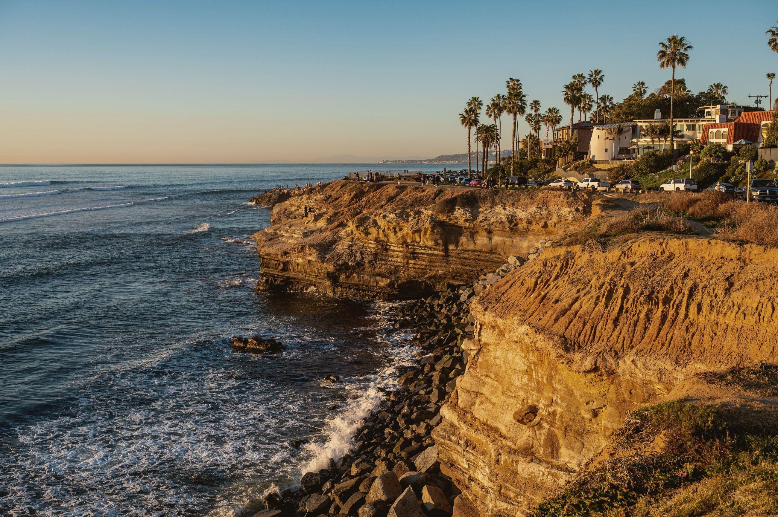 Sandstone cliffs above the Pacific at San Diego, late afternoon, palms along the ridge.
